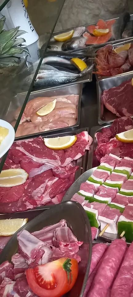 A chilled counter display of raw and cured meats