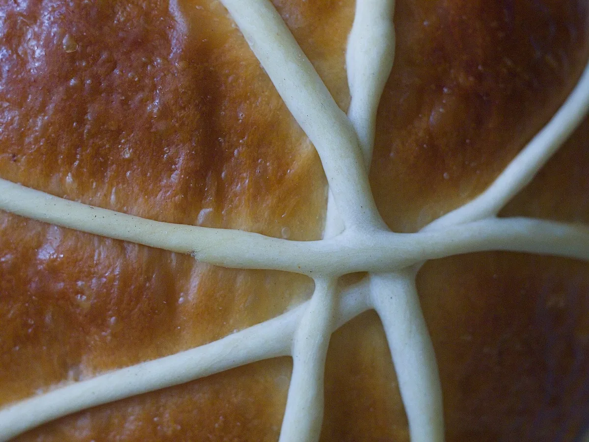Round golden arrufada sweet bread from Coimbra on a wooden board