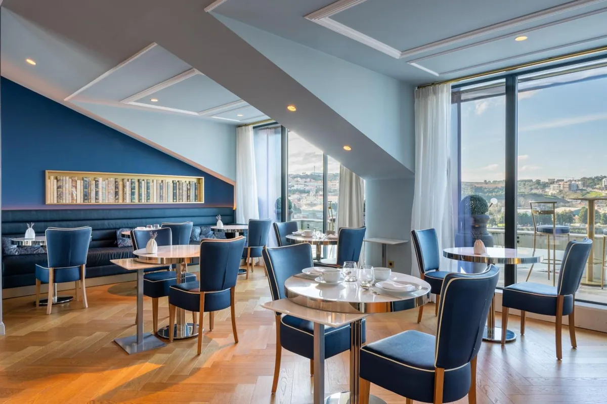 The blue-panelled dining room at CBR Boutique Hotel, Coimbra, with windows over the city
