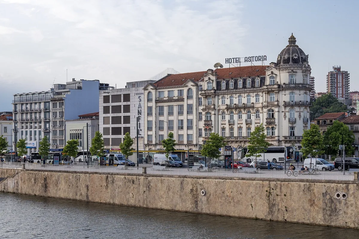 The curved flat-iron facade of Hotel Ast&oacute;ria on the Coimbra riverfront