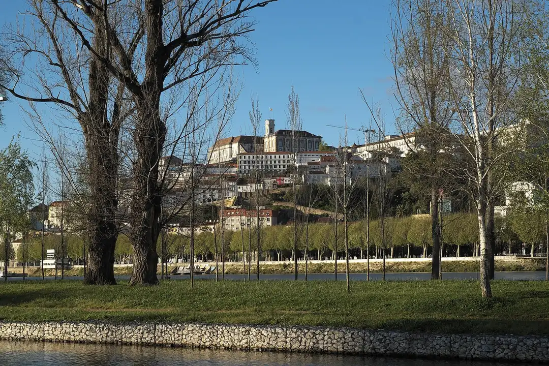 Coimbra&rsquo;s university hill rising above the Mondego river at dusk