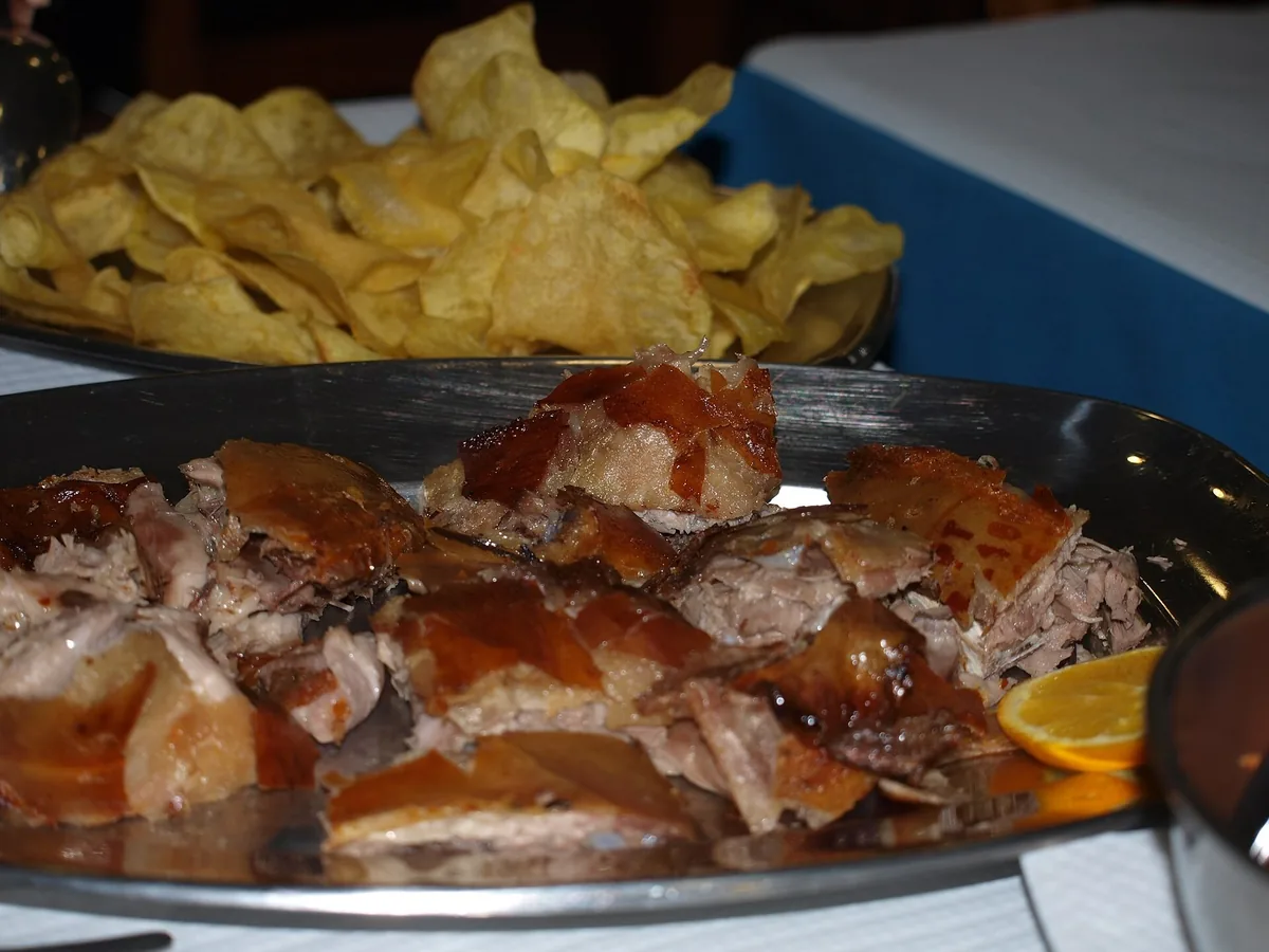 Roast suckling pig with crisp crackling being carved in the Bairrada
