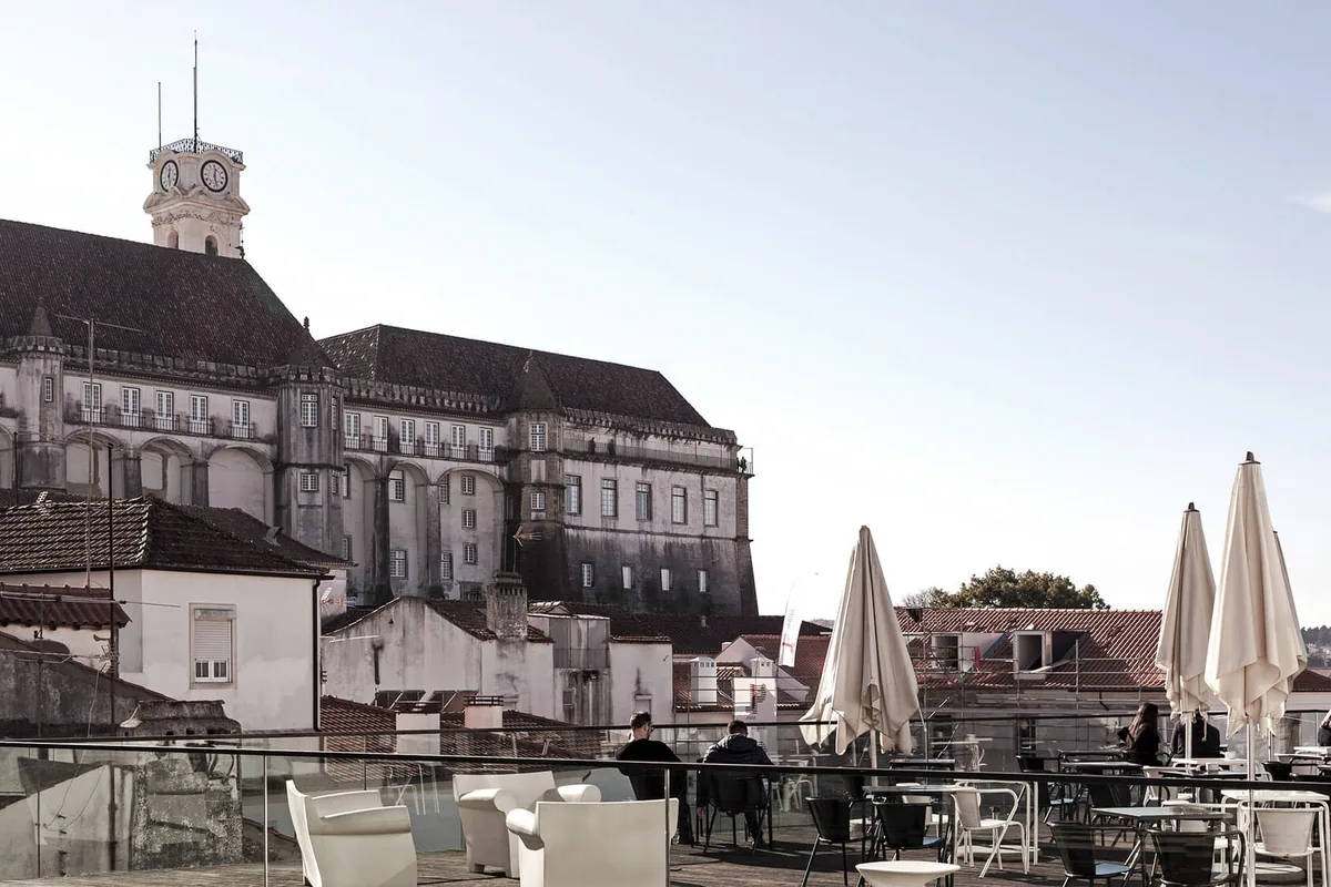 Terrace tables and folded parasols above the rooftops of the Alta, Coimbra