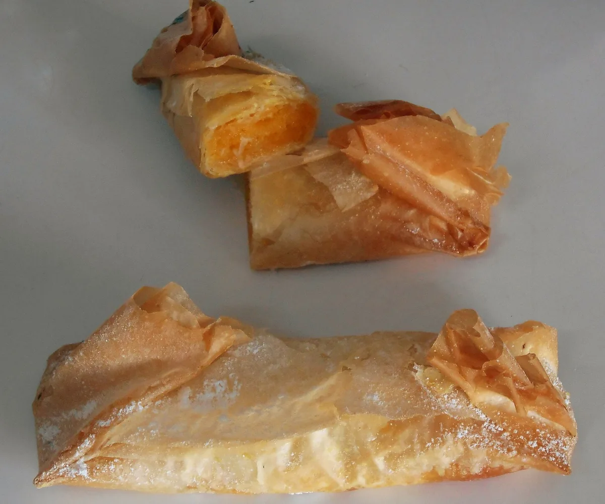 Cylindrical pastéis de Tentúgal dusted with icing sugar