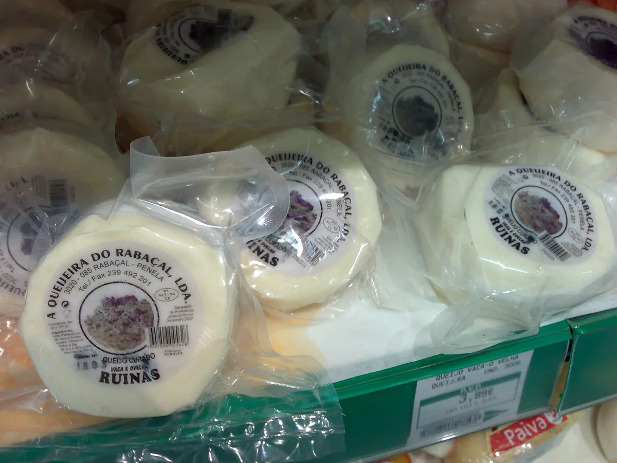 A small round Queijo Rabaçal cheese cut open on a board