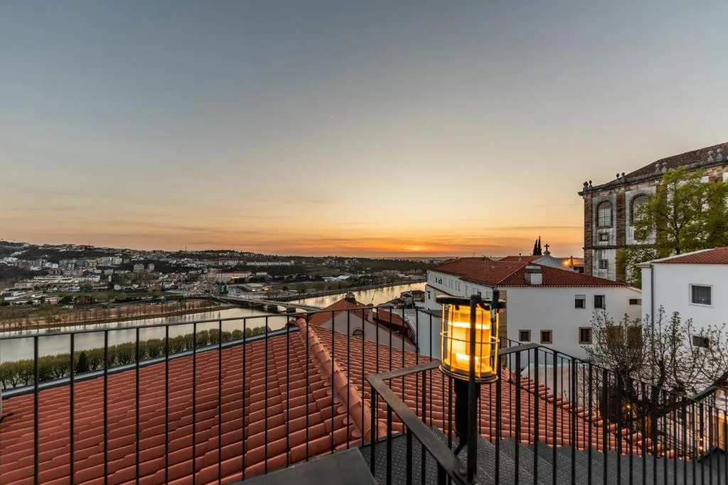 The rooftop terrace at Sapientia Boutique Hotel at sunset, over the roofs of Coimbra
