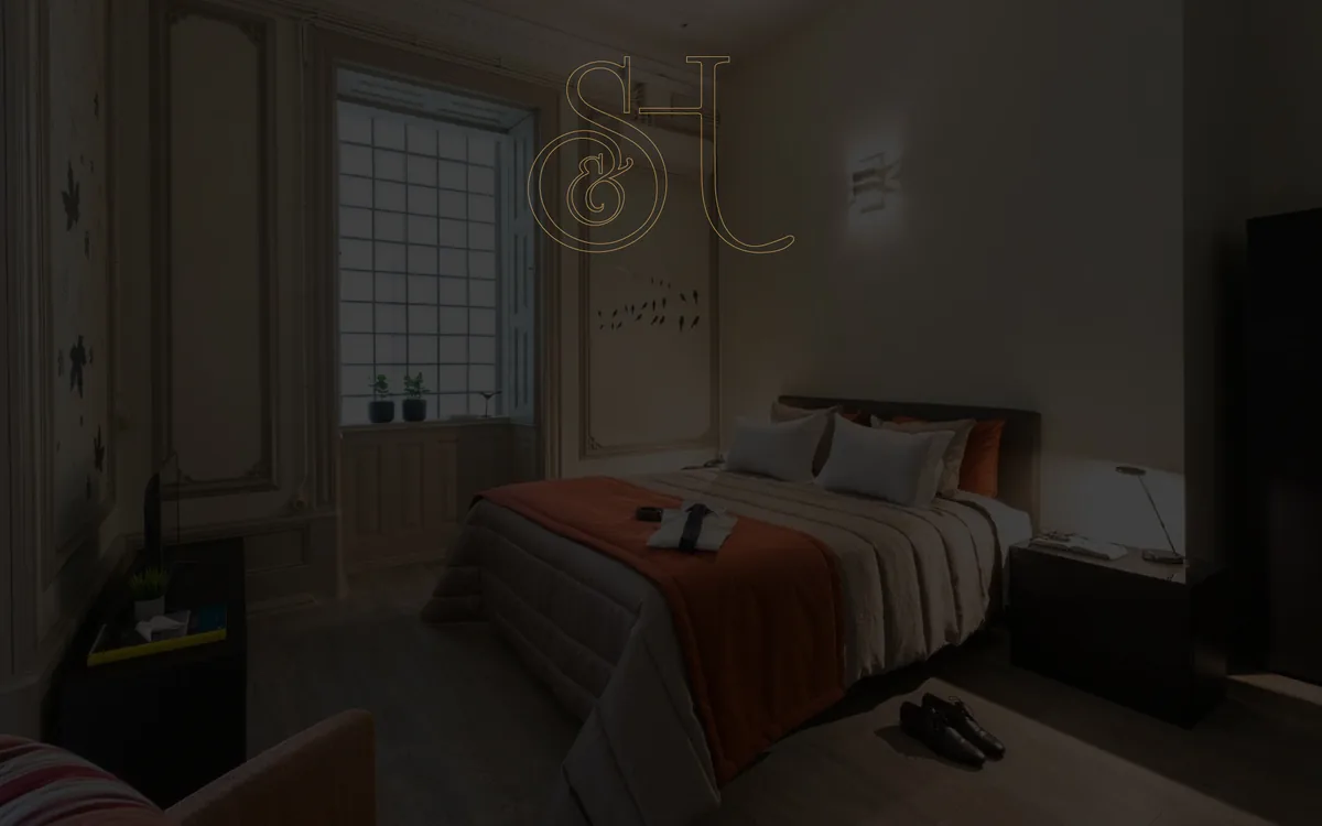 A room at Serenata Hostel, Coimbra, with the house monogram on the wall