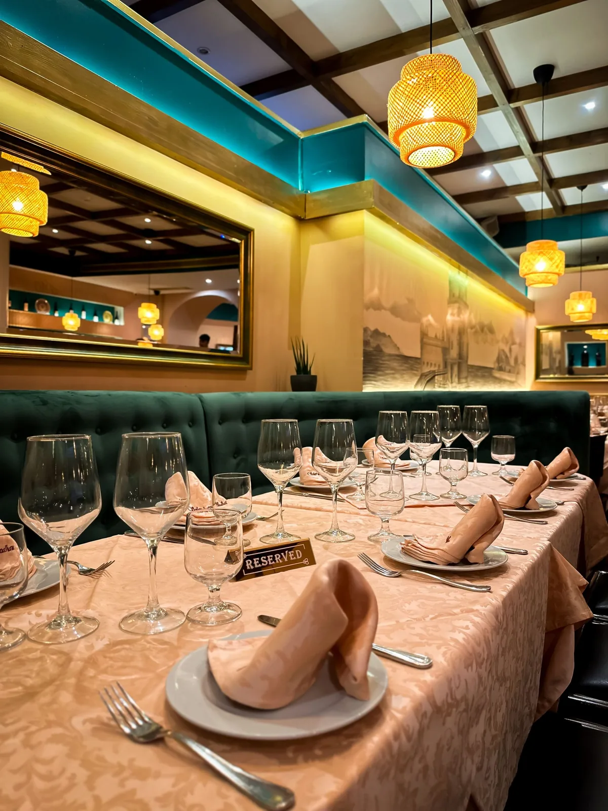 A long table laid for service under gold pendant lamps at Solar do Bacalhau, Coimbra