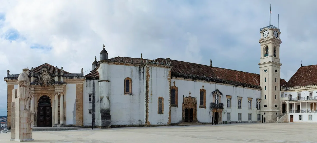 A guide addressing a small group in the Paço das Escolas courtyard, Coimbra
