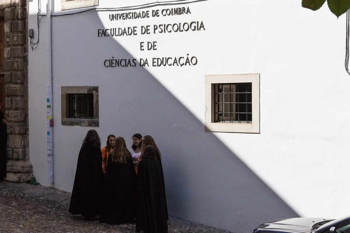 Students in black academic capes on the steps of the Old Cathedral in Coimbra