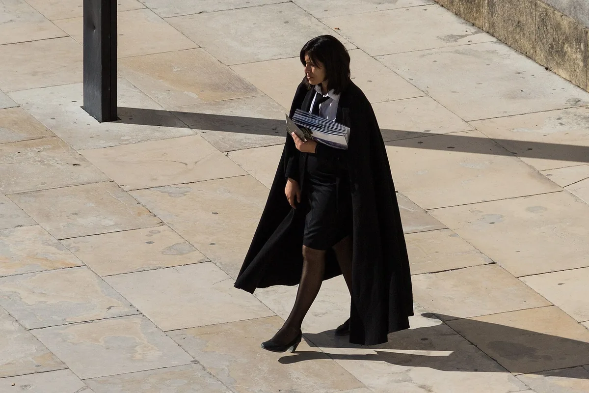 Coimbra students in the black traje acad&eacute;mico on the steps of the Old Cathedral